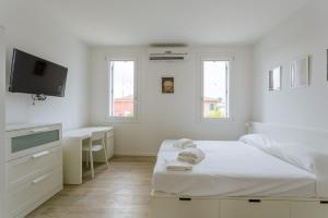 a white bedroom with two beds and a desk at Yourbanflat White River 2 in Padova