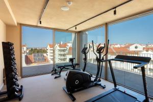 a gym with two treadmills and exercise bikes in a room with windows at Upon Vila - Alcochete Hotel in Alcochete