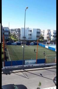 un campo de fútbol con gente jugando al fútbol en una cancha en Appartement à Blanca Beach., en Casablanca