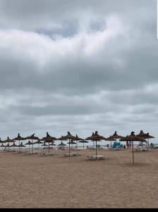 una fila de sombrillas en una playa con el océano en Appartement à Blanca Beach., en Casablanca