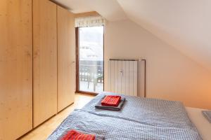 - une chambre avec un lit et une grande fenêtre dans l'établissement Apartment Planika, à Bohinj