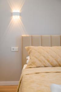 1 dormitorio con 1 cama con luz en la pared en Уютная двушка по улице Абая, en Almaty