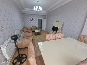 un soggiorno con tavolo bianco e divano di Garden City Sumqait 3 oda 100m2 daire a Sumqayıt