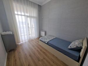 una piccola camera con letto e finestra di Garden City Sumqait 3 oda 100m2 daire a Sumqayıt