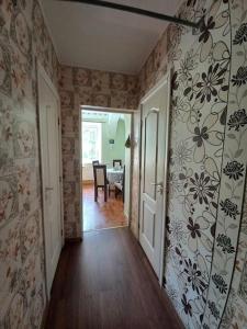 an empty hallway with a room with floral wallpaper at Quite House in Liepāja