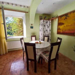 a dining room with a table and chairs and a window at Quite House in Liepāja