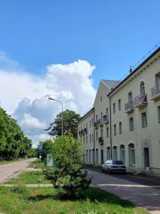 a street with buildings and a car parked on the road at Quite House in Liepāja