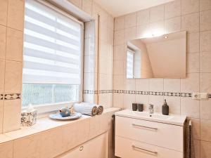 baño con lavabo, espejo y ventana en Ferienwohnung -Time to relax- bei Bamberg, mit herrlichem Blick auf das Maintal, en Viereth-Trunstadt
