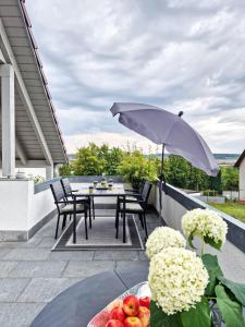un patio con mesa y sombrilla en Ferienwohnung -Time to relax- bei Bamberg, mit herrlichem Blick auf das Maintal en Viereth-Trunstadt