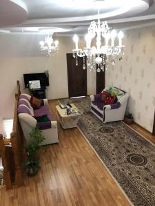 - un salon avec deux canapés et un lustre dans l'établissement Guest House Ulukbek, à Bokonbayevo