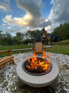 a fire pit with a chair on top of it at Cabana A-frame Cricov 9 in Valea Lungă-Ogrea