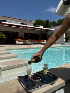 a person pouring wine into a bowl of food next to a pool at VAR ZENITUDE in Lorgues