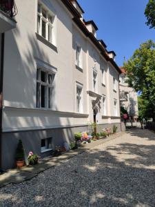 un edificio blanco con flores delante en Kamienica Ogrodowa Rooms, en Sopot