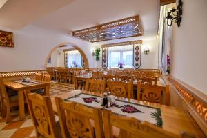 comedor con mesas y sillas de madera en Pod Tatrami 1 - świetna lokalizacja - sauna infared oraz grota solna - jedno wejście gratis en Białka Tatrzanska