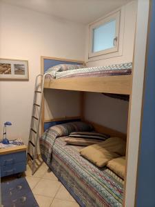Ce dortoir comprend 2 lits superposés et une fenêtre. dans l'établissement Amazing apartment for 6 person with sea view terrace by Beahost Rentals, à Bibione