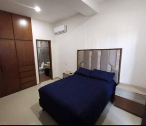 1 dormitorio con cama azul y espejo en Hermoso alojamiento vacacional, en Mazatlán