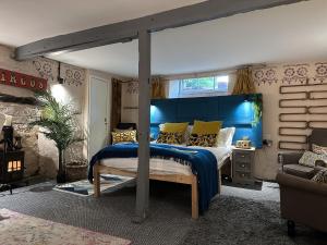 a bedroom with a bed with a blue headboard at One Drake Road, Tavistock, Devon in Tavistock