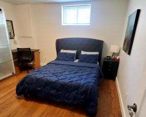 una camera da letto con un letto con un piumone blu di Spacious Guest Suite a Hamilton