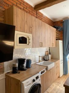 斯武普斯克Apartments PSD - Anny Łajming 1A的厨房配有木制橱柜和白色的电器