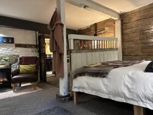 1 dormitorio con 1 cama y 1 silla en One Drake Road, Tavistock, Devon en Tavistock