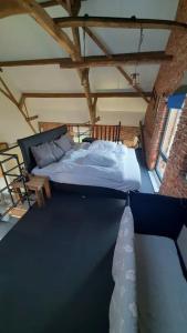um quarto com uma cama grande num sótão em appartement in authentiek koetshuis met bedstee em Moerstraten