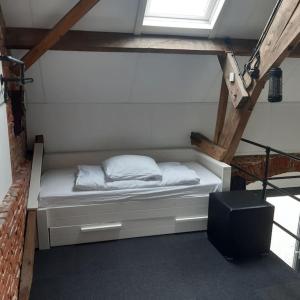 uma cama branca num quarto com uma janela em appartement in authentiek koetshuis met bedstee em Moerstraten