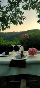 a white table with wine glasses and flowers on it at B&B degli Allori in Moggiona