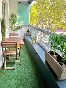 einen Balkon mit einem Tisch, Stühlen und Pflanzen in der Unterkunft Spacious Cozy Apartment close Paris & Flea Market at St Ouen in Saint-Ouen