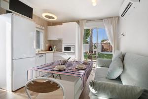 eine Küche und ein Wohnzimmer mit einem Tisch und einem Sofa in der Unterkunft Estudio Limón y Sal in Chiclana de la Frontera