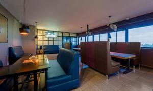 a restaurant with a blue couch and a table and chairs at Treebo Eden Park Hotel, 3 Km From Puducherry Airport in Puducherry
