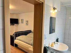 a bathroom with a bed and a sink and a mirror at Engelhard´s Ferien Apartment in Hillesheim