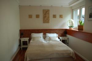1 dormitorio con 1 cama con 2 mesas y una ventana en Apartament 200 m od morza, en Sopot