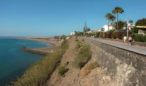 a road next to the ocean and a beach at Bungalow Carmen in San Bartolomé
