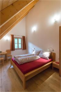 a bedroom with a large bed with a red blanket at Gästehaus Biohof Leutschach in Leutschach