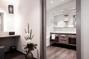 山夫顿堡Nuhr Medical - Hotel & Restaurant的浴室设有水槽和花瓶