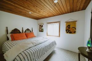 a bedroom with a bed with a wooden ceiling at 1970s retro vibe - The Creamsicle - Lake Huron Oliphant in Wiarton