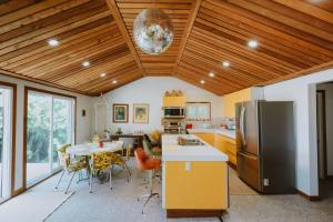 uma cozinha com uma mesa e um frigorífico em 1970s retro vibe - The Creamsicle - Lake Huron Oliphant em Wiarton