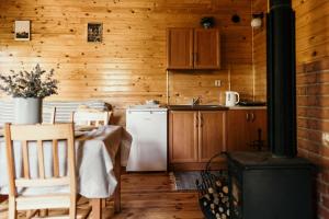 a kitchen with a table and a white refrigerator at Domek na Mazurach Mrągowo in Mrągowo