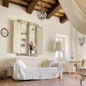 a living room with a white couch and a chandelier at Spello House Altana in Spello