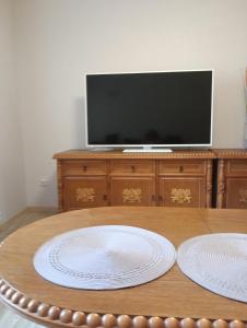 duas placas brancas numa mesa de madeira com uma televisão em Apartament Osiedle Bajkowe em Ostrów Wielkopolski