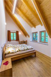 Gästehaus Biohof Leutschach في ليوتسشاخ: غرفة نوم بسرير في غرفة بسقوف خشبية
