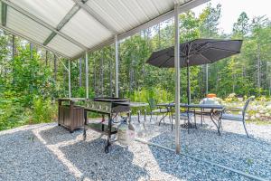 eine Terrasse mit einem Tisch und einem Sonnenschirm in der Unterkunft Rustic Roost-5 acres, Fenced, Fire Pit, RV option & MTN View in Dahlonega