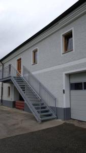 un edificio blanco con una escalera junto a un garaje en außergewöhnliches loft in ehemaligem stallgebäude 