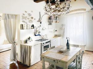 a kitchen with a table and a chandelier at Spello House Altana in Spello +21 photos