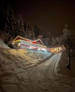 a ski lodge in the snow at night at All inclusive villa with everything you need in Lillehammer
