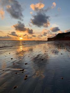 einen Sonnenuntergang am Strand mit Sonnenuntergang in der Unterkunft Uma casa para descansar em um cenário paradisíaco. in Icapuí