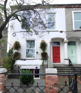 a white house with a red door at Eglinton Road - Super King - Private Bathroom in Bray