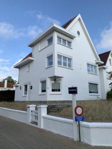a white house with a sign in front of it at Villa Le Renard in Knokke-Heist