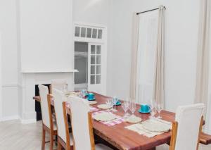 a dining room with a wooden table and chairs at Paphiri House in Zomba
