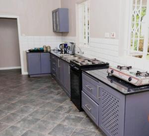 a kitchen with purple cabinets and a counter top at Paphiri House in Zomba +9 photos